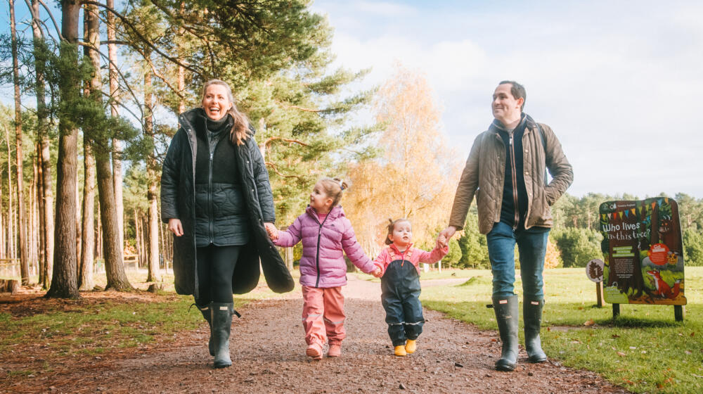 A family of four walking in the woods