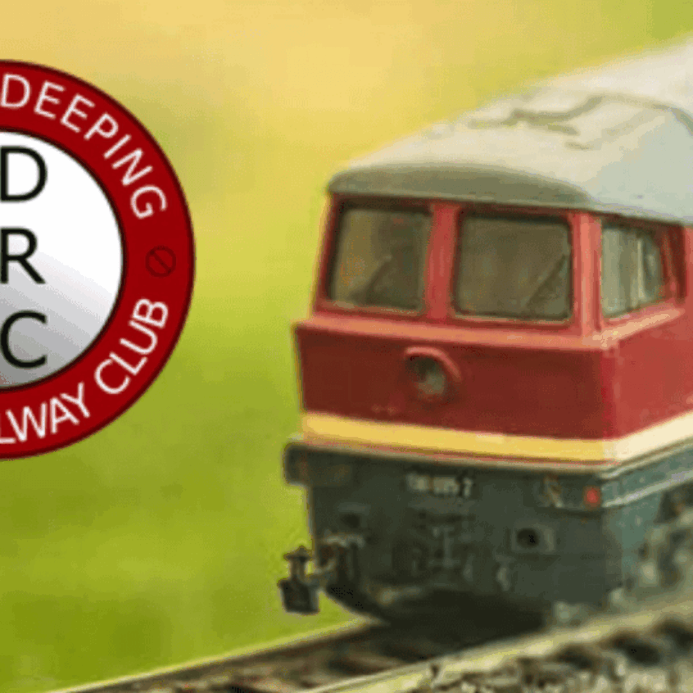 Stamford Model Railway Show Enthusiasts exploring detailed model train displays at the Stamford Model Railway Show, featuring intricate miniature landscapes, trains, and tracks in a bustling event setting.