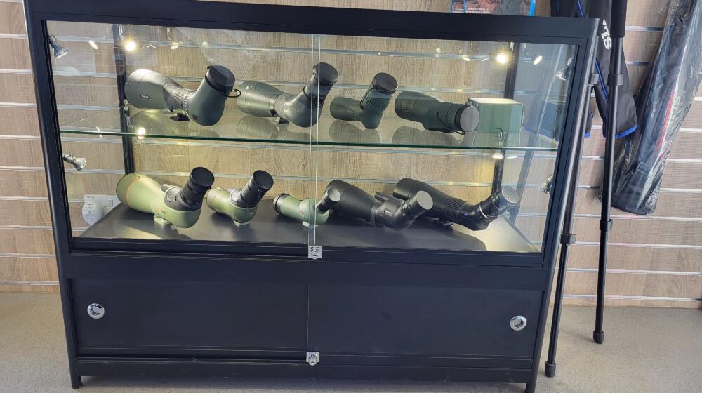 A glass cabinet containing several telescopes at the In Focus optics shop Rutland Water